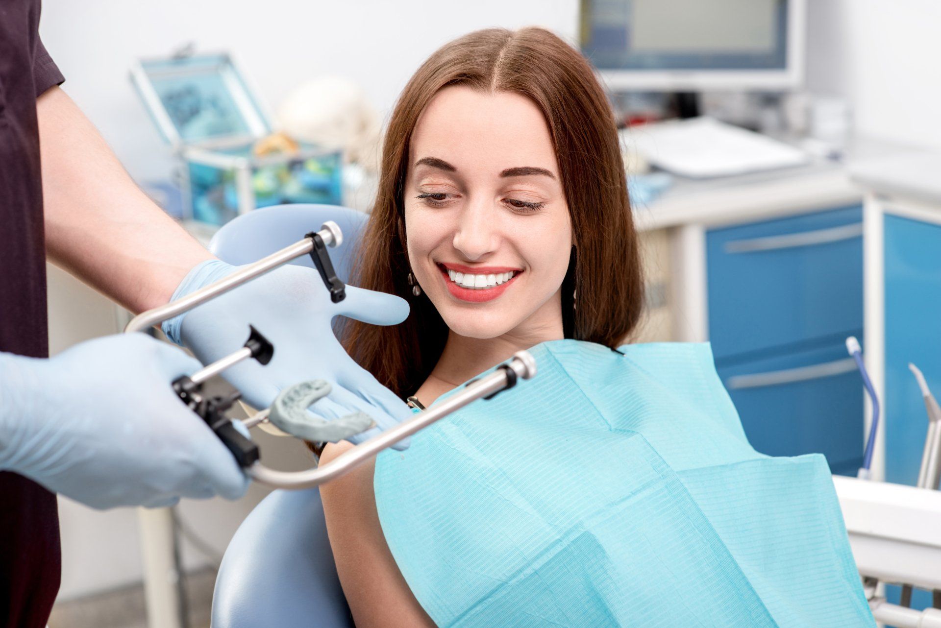a woman is smiling while sitting in a dental chair .