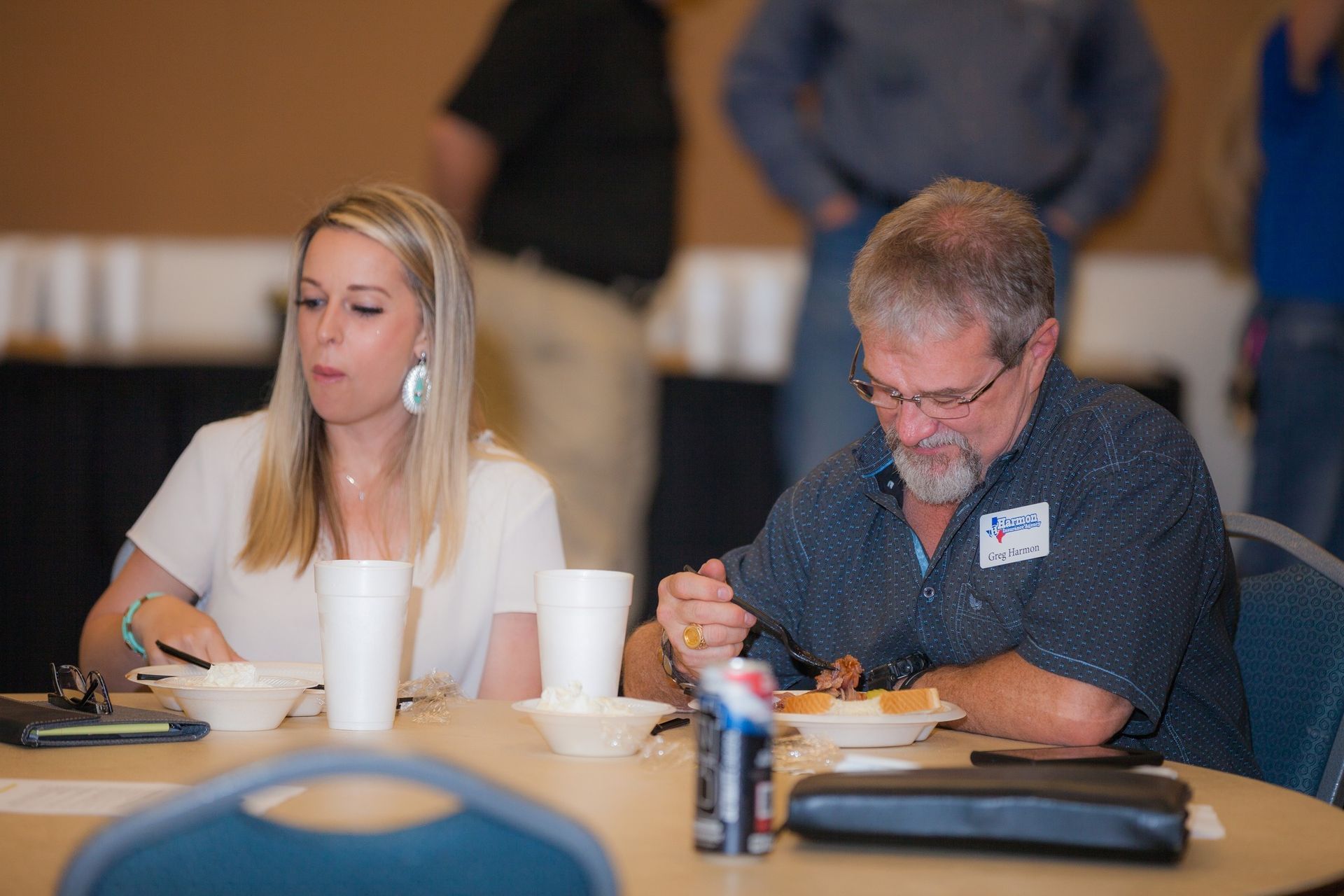 A man and a woman are sitting at a table eating food.