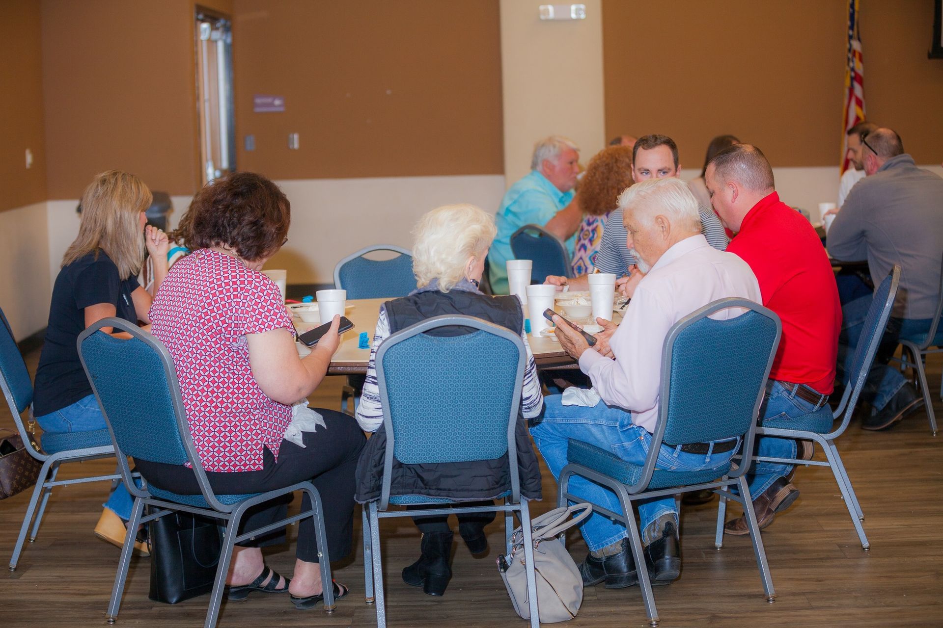 A group of people are sitting around a table in a room.
