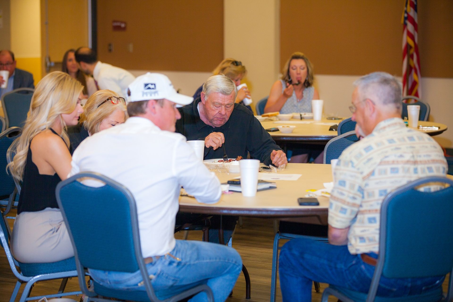A group of people are sitting around a table talking to each other.