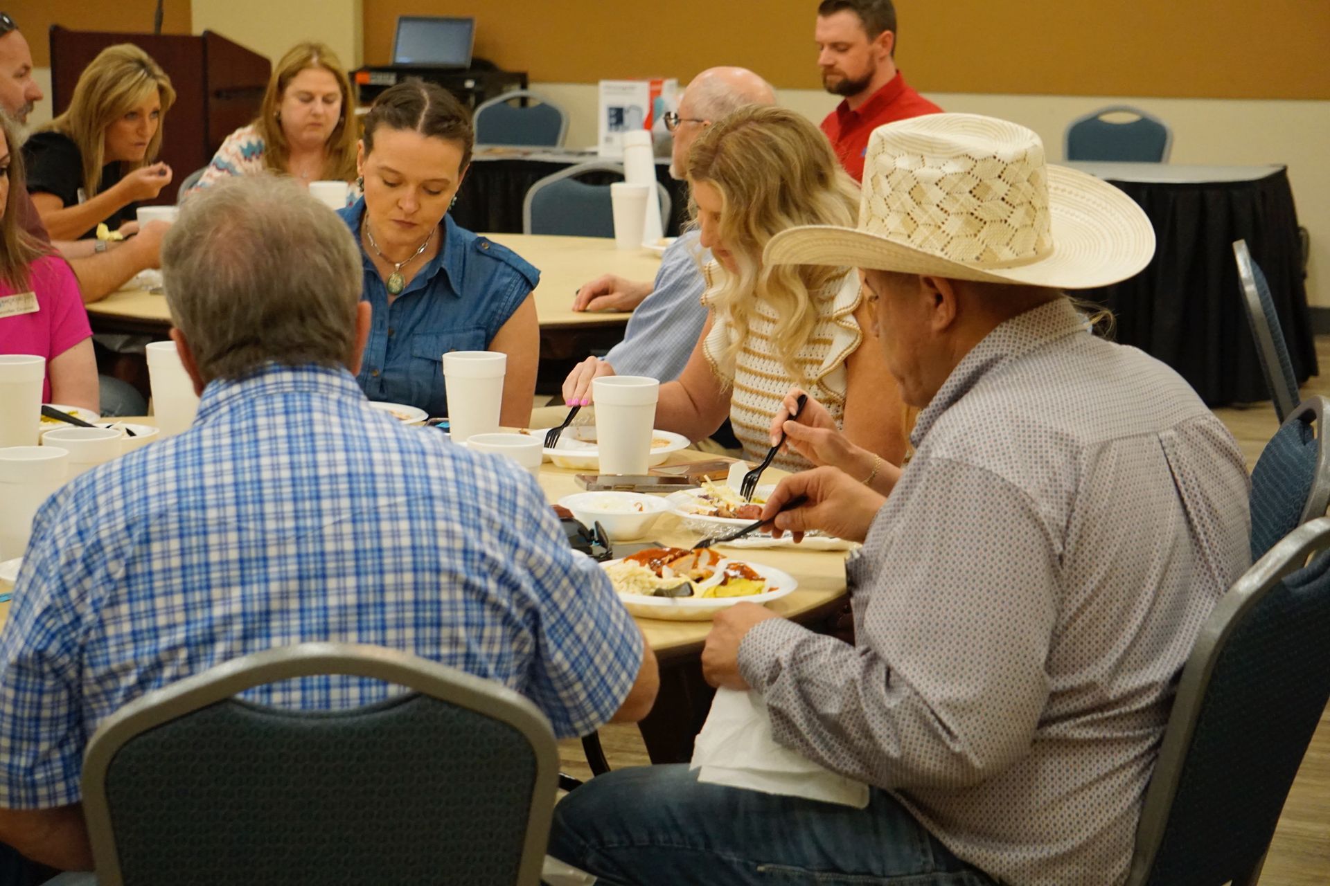 A group of people are sitting around a table eating food.