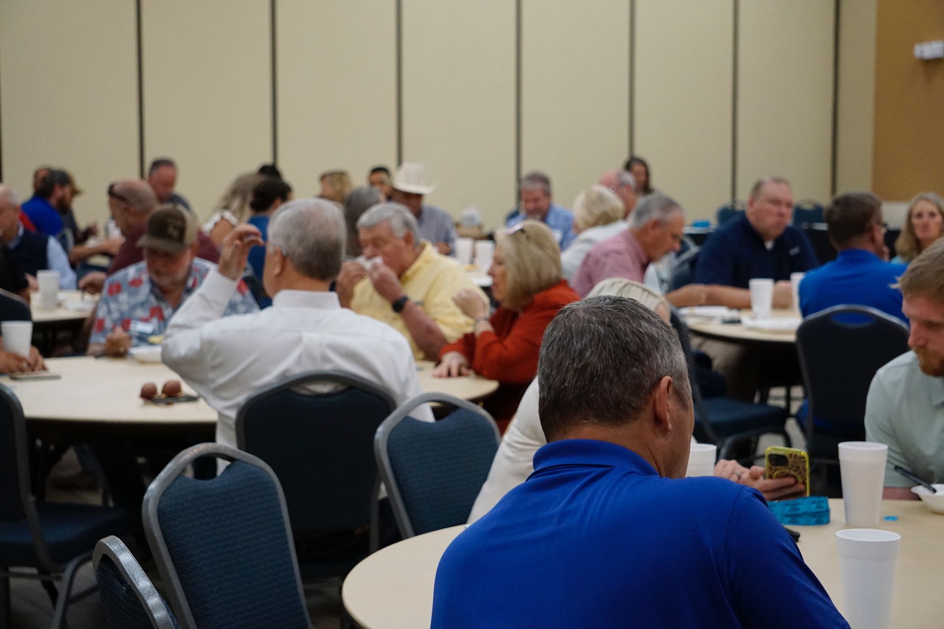 A group of people are sitting at tables in a room.