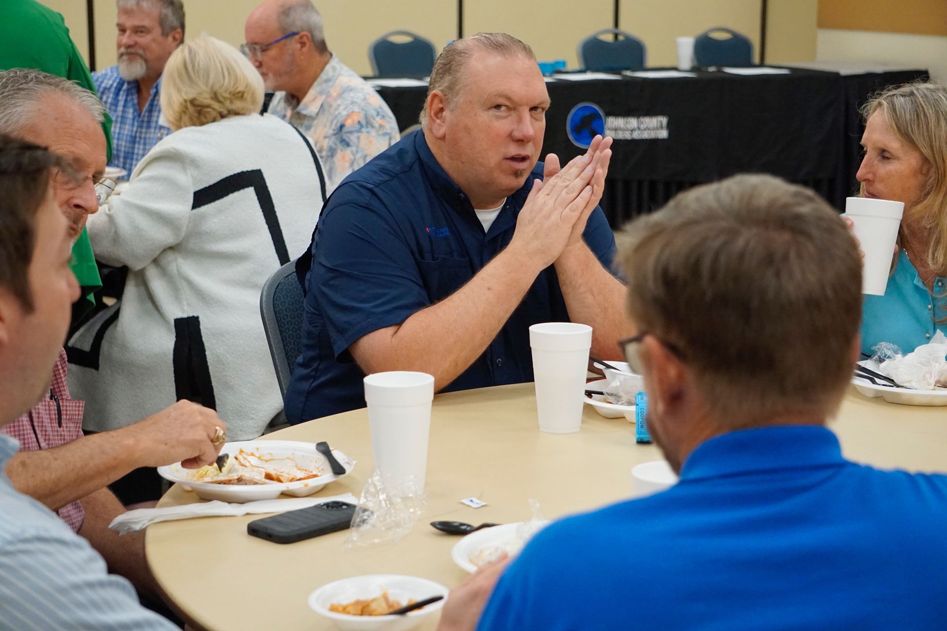 A group of people are sitting around a table eating food.