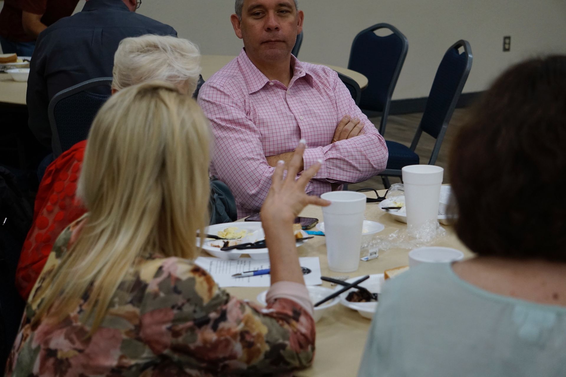 A group of people are sitting at a table talking to each other.