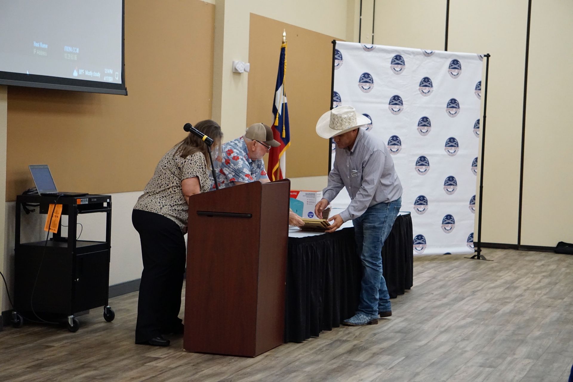 A man and a woman are standing at a podium in a room.