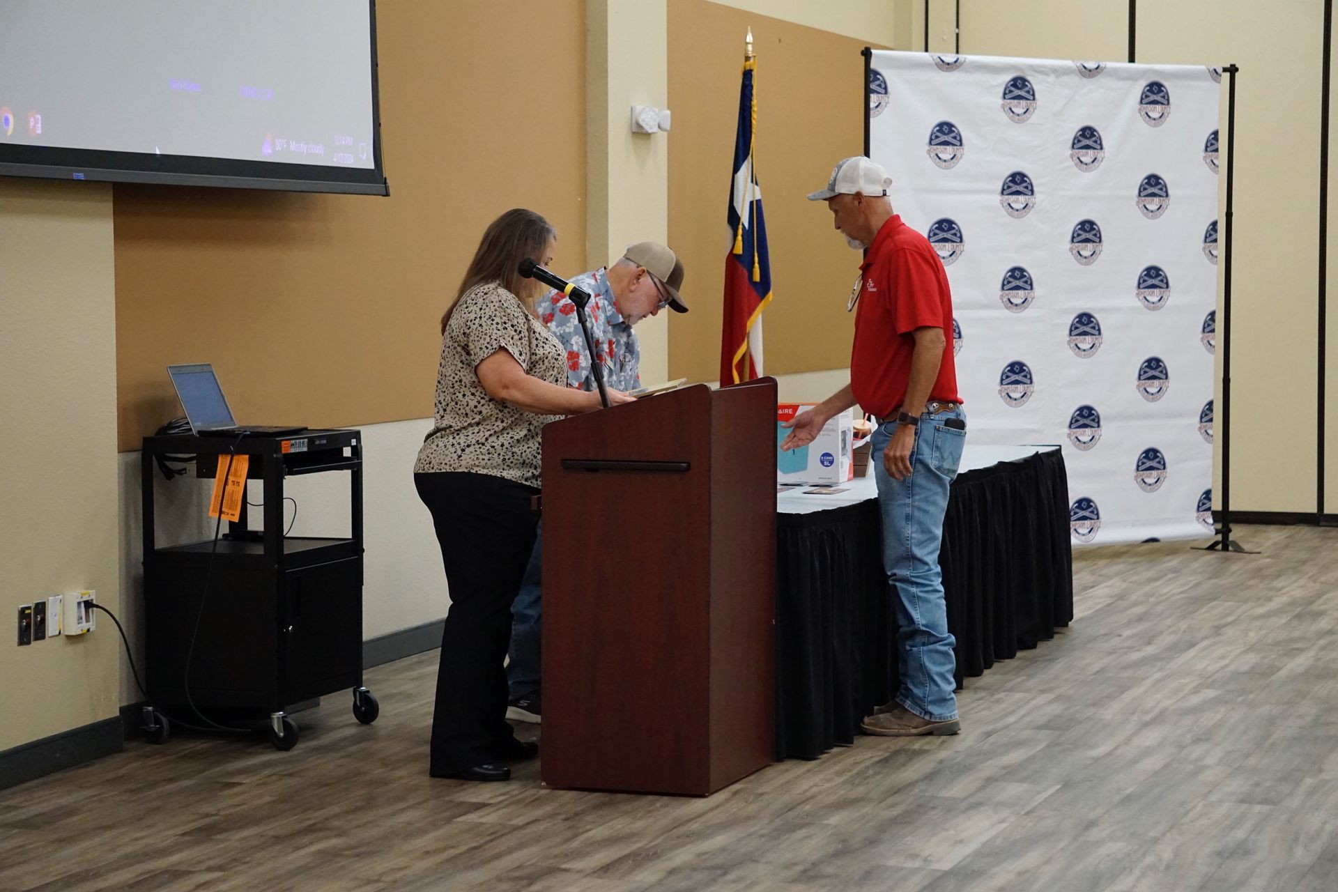 A group of people are standing around a podium in a room.