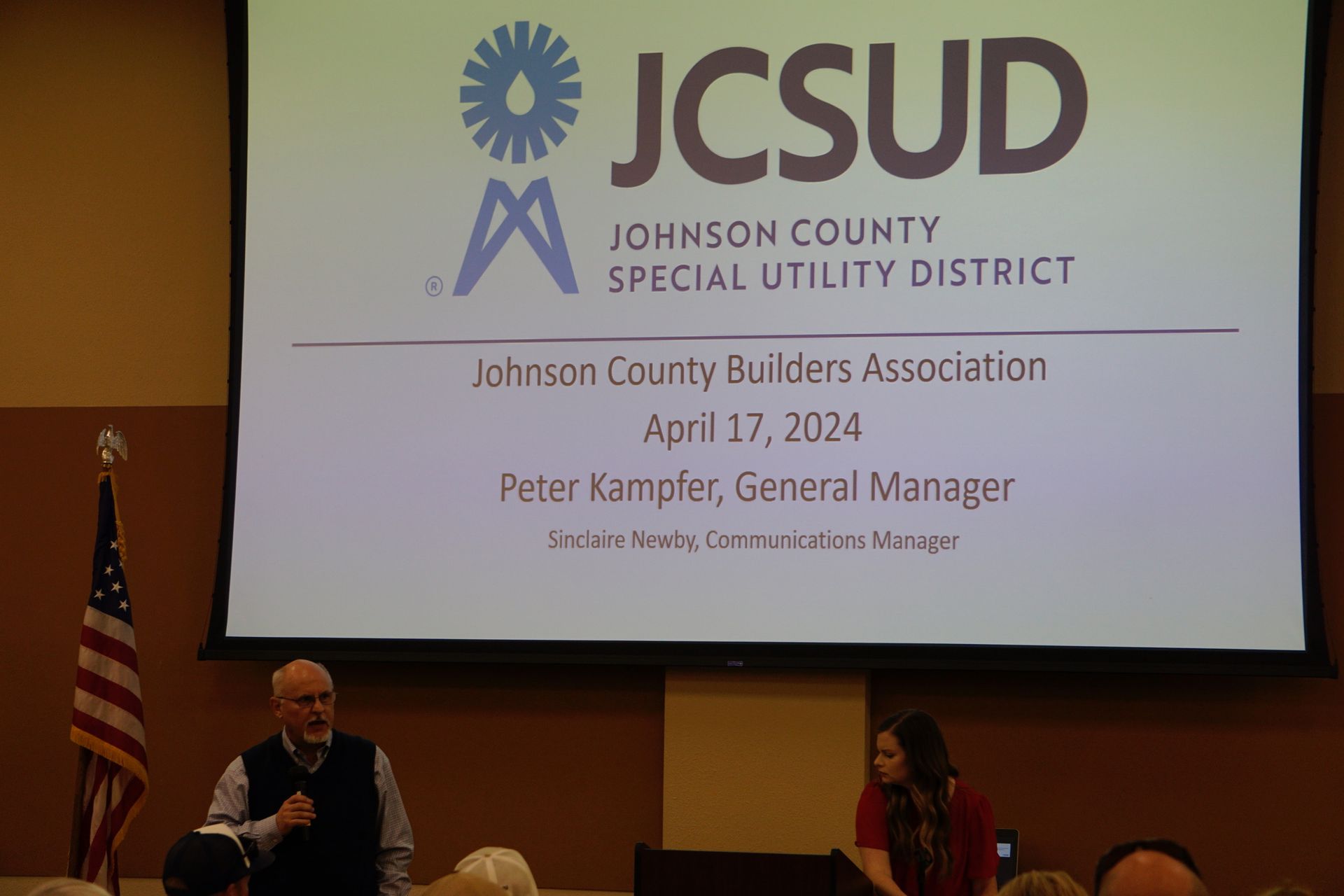 A man is standing in front of a screen that says johnson county special utility district