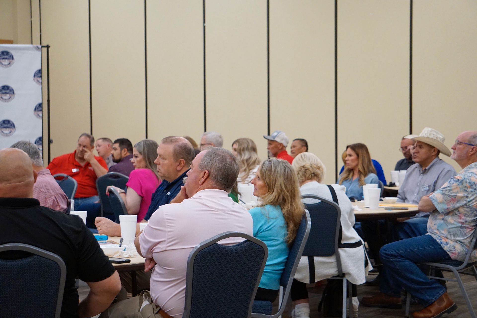 A group of people are sitting at tables in a room.