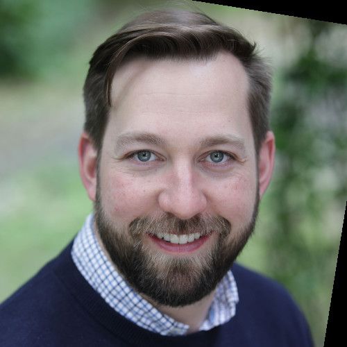 A woman wearing a white turtleneck and jacket