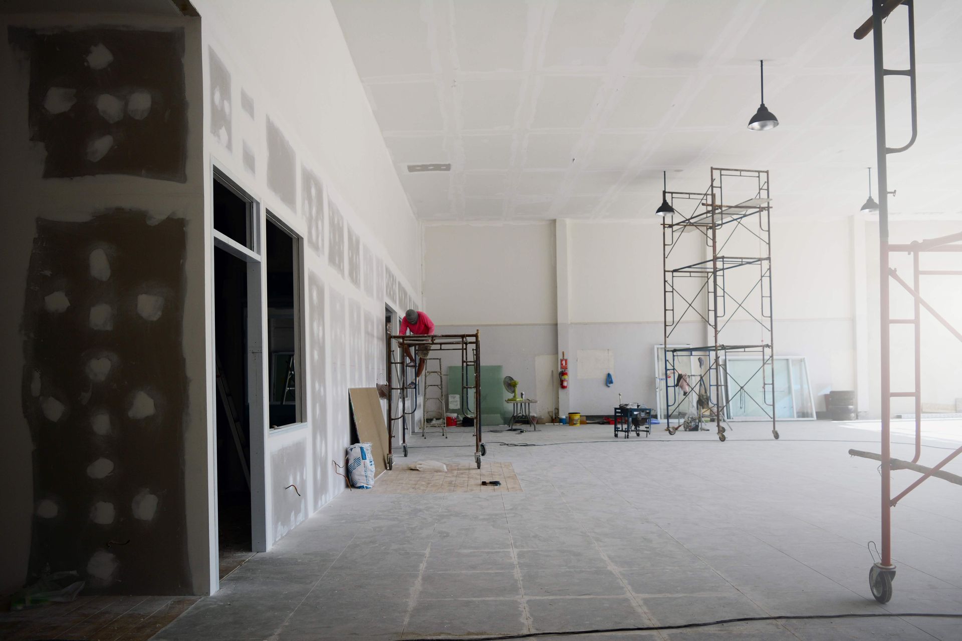 Commercial interior under construction with scaffolding and drywall work.