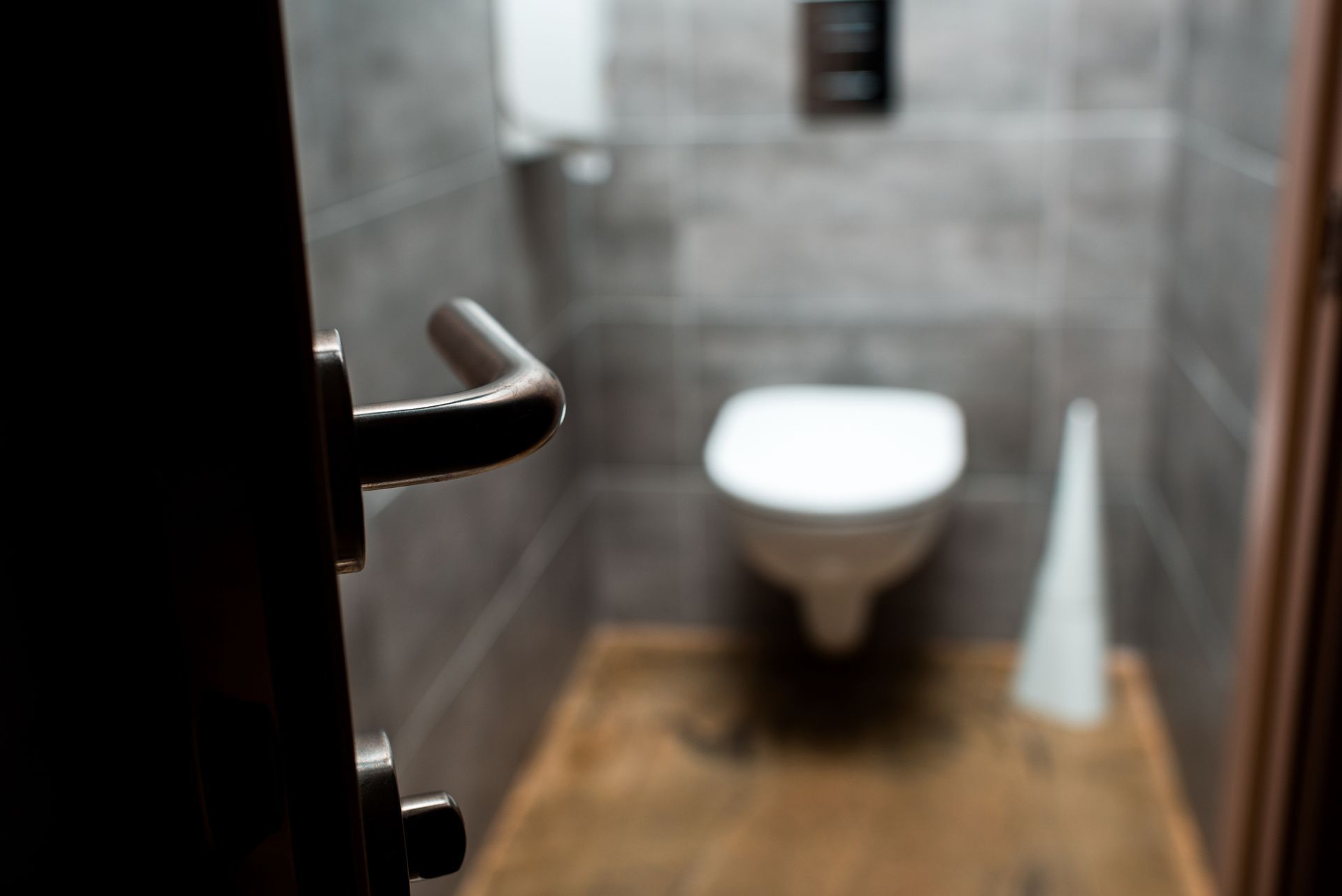 a blurred image of a toilet in a bathroom with a door open .