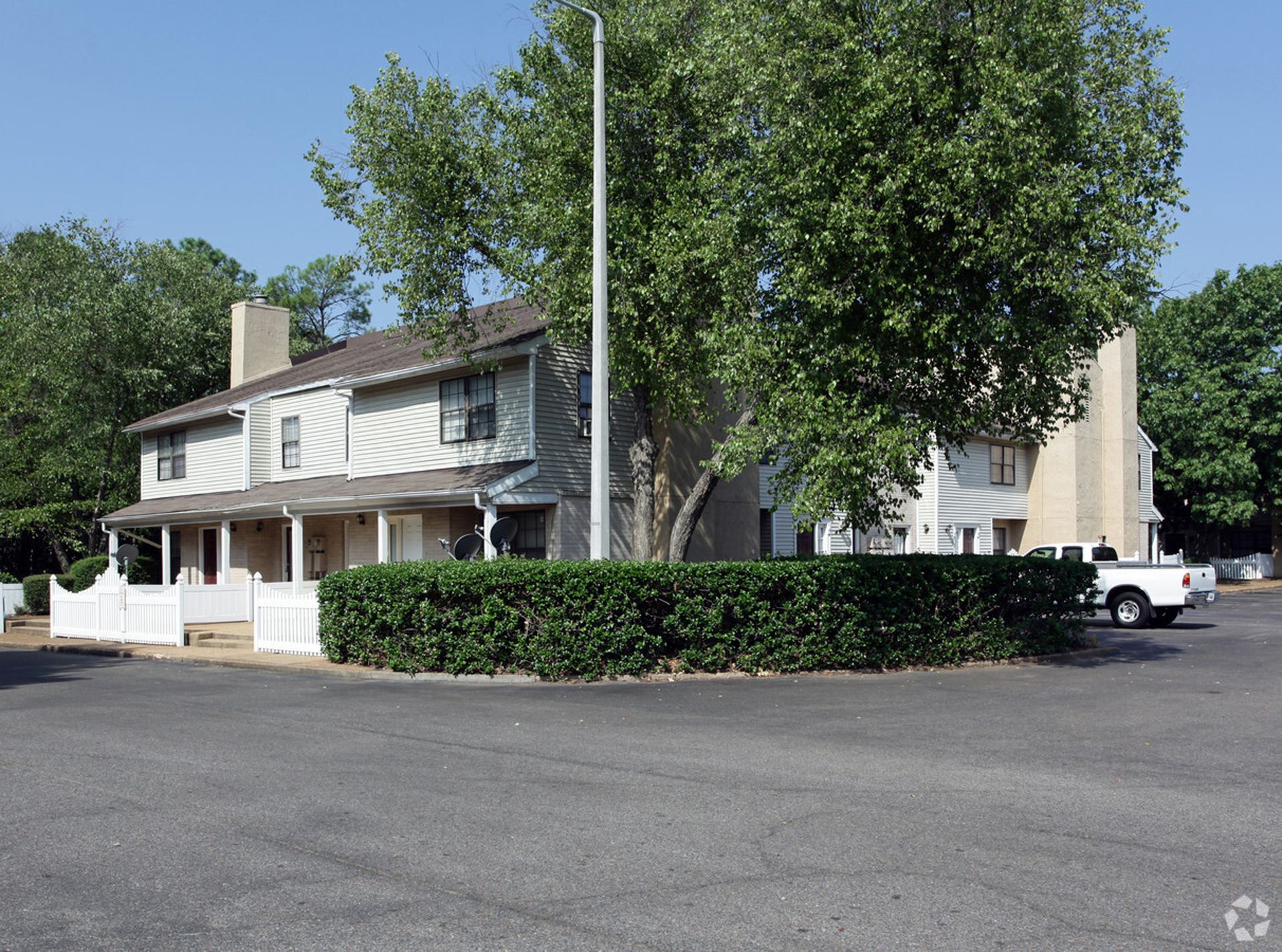 A white house with a white pick up truck parked in front of it