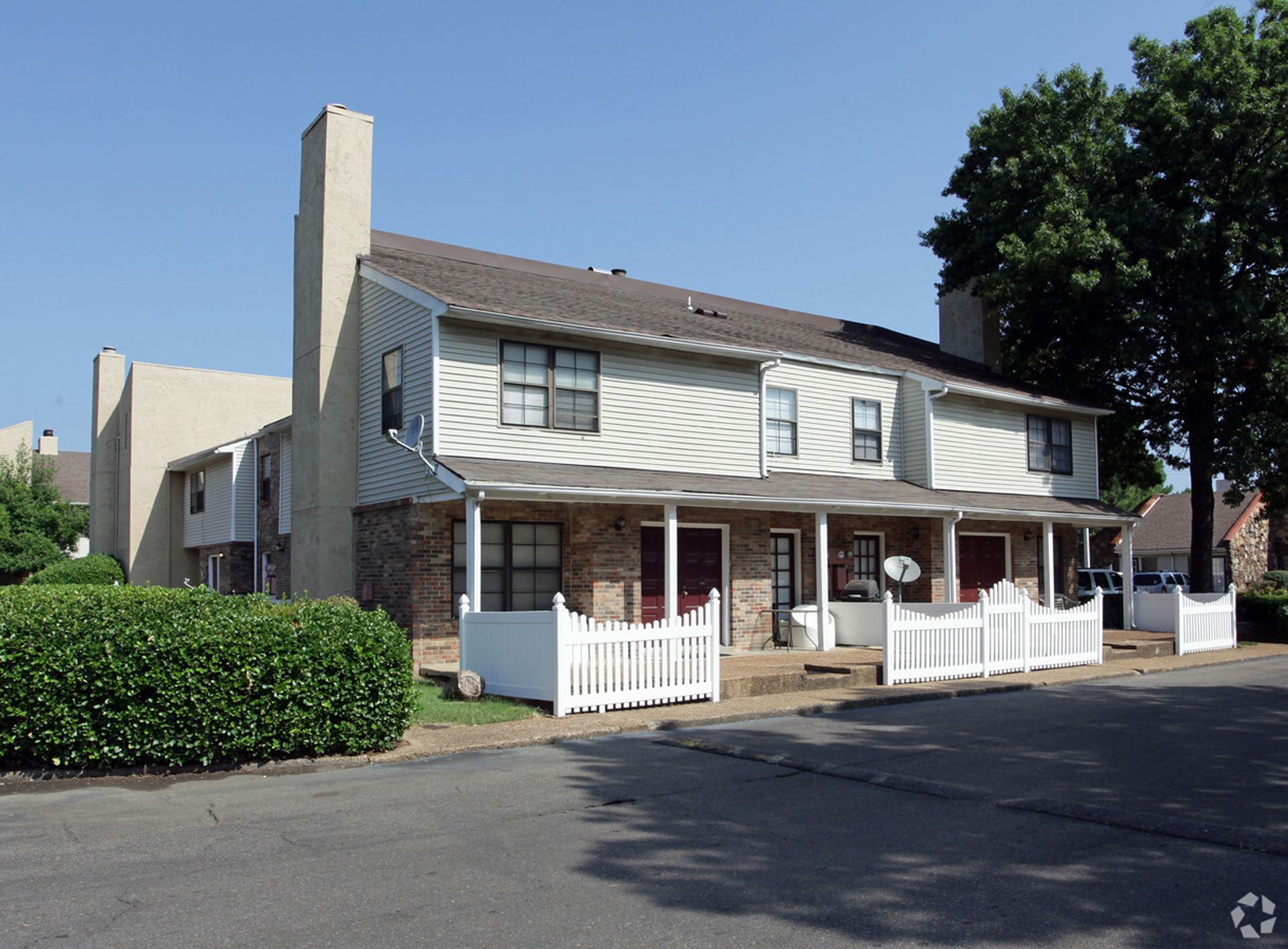 A white house with a porch and a white fence