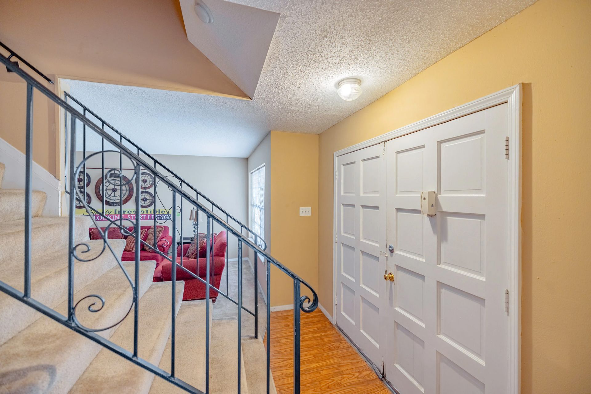A hallway with stairs leading up to a living room.