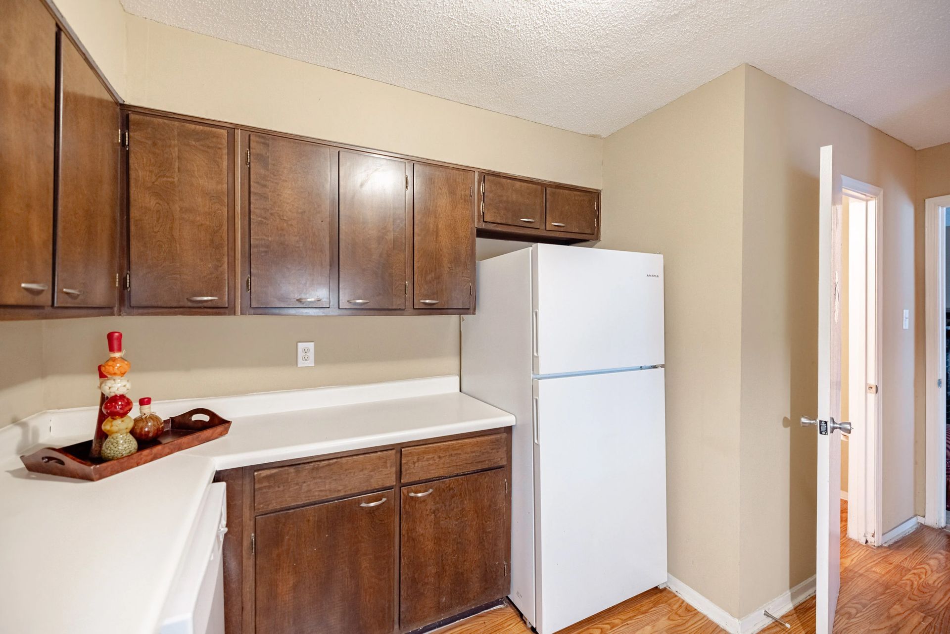 A kitchen with brown cabinets and a white refrigerator