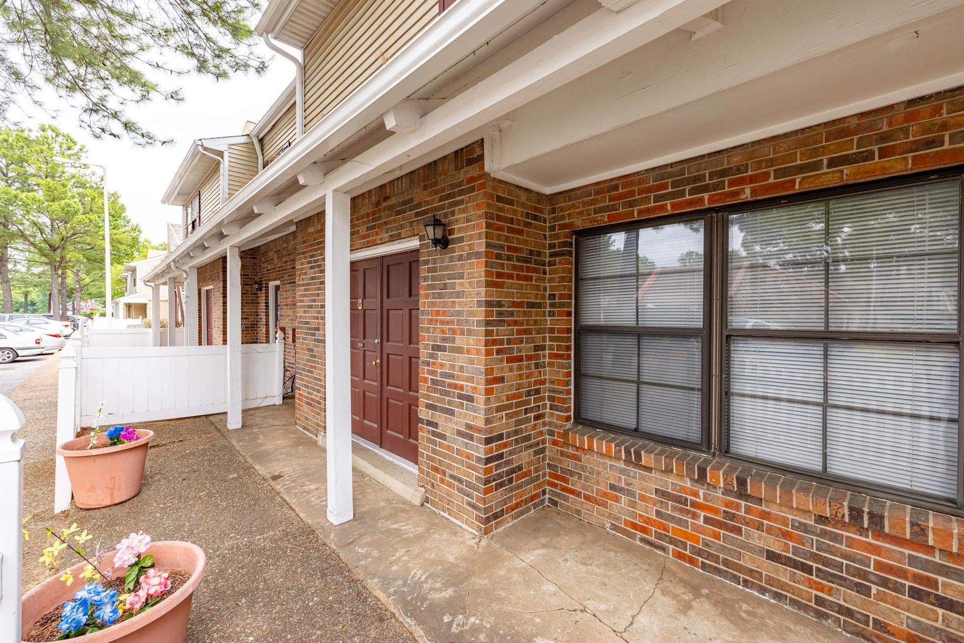 A brick building with a porch and a window.