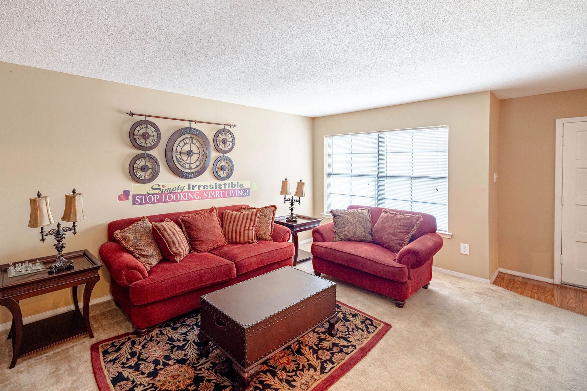 A living room with two red couches and a coffee table