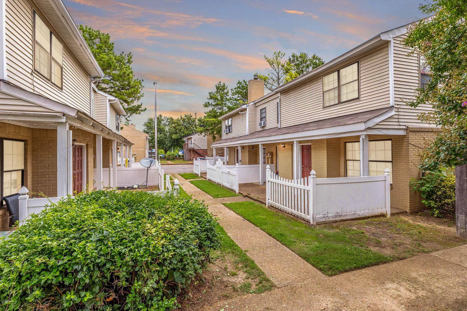 A row of houses with a white picket fence in a residential area.