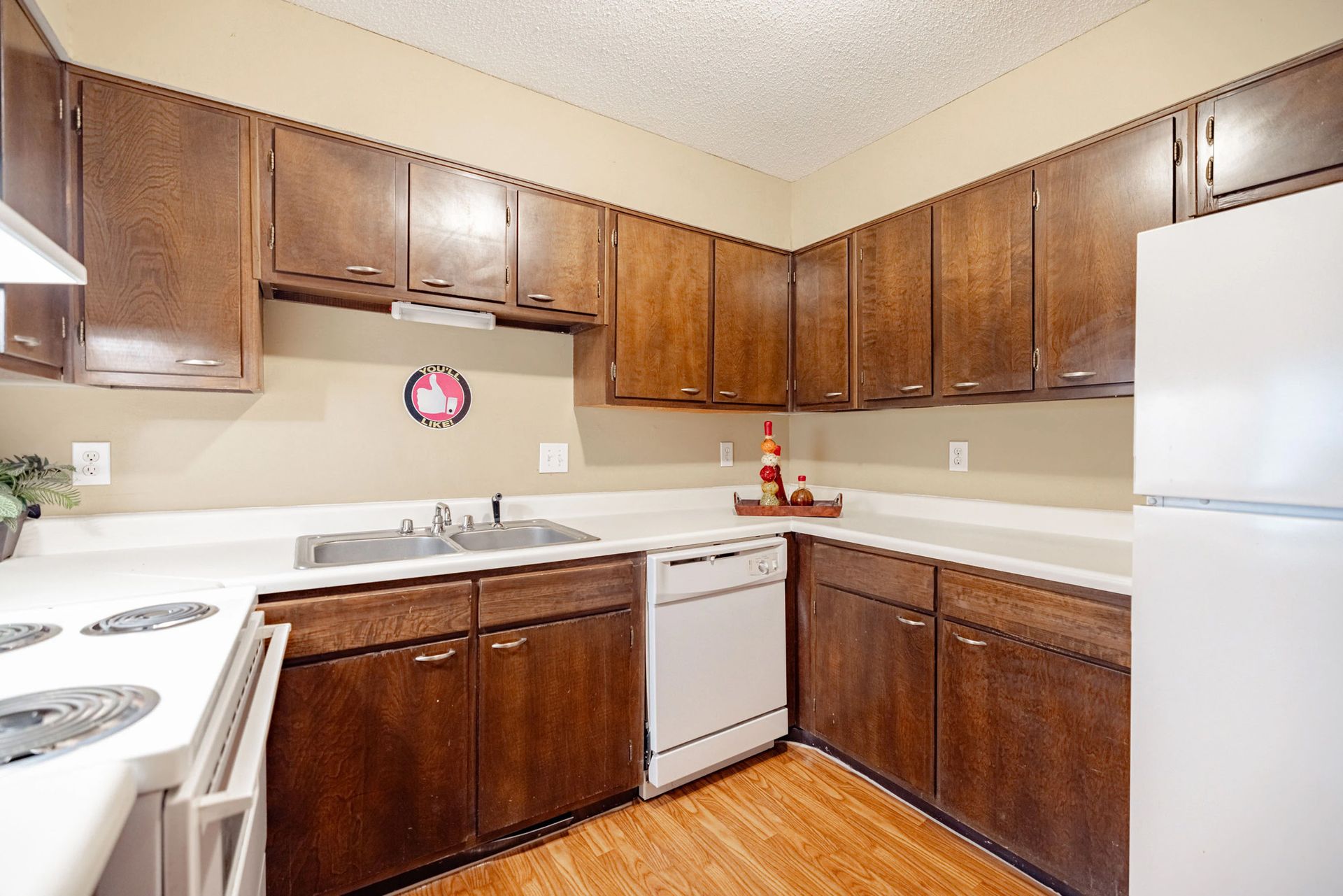 A kitchen with wooden cabinets and white counter tops