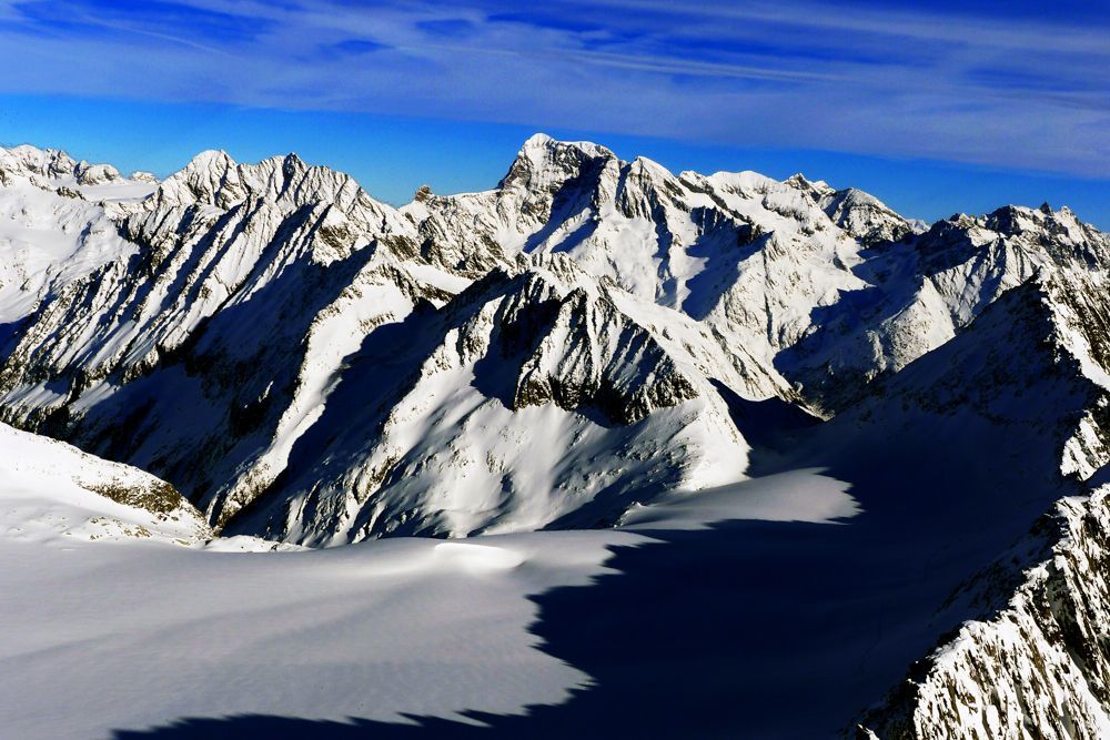 Eine schneebedeckte Bergkette mit einem blauen Himmel im Hintergrund