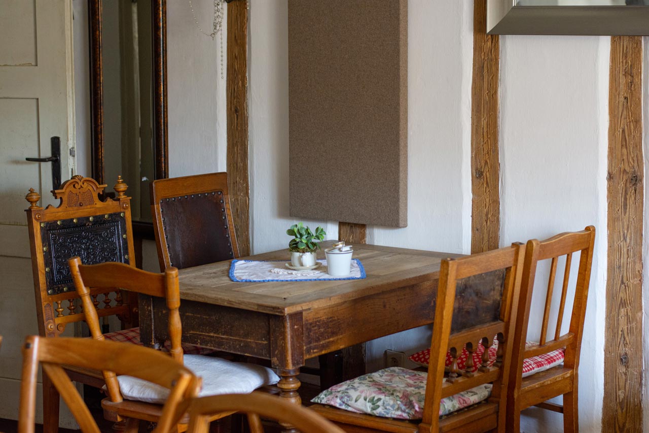Ein Holztisch und Stühle in einem Raum mit einem Spiegel.