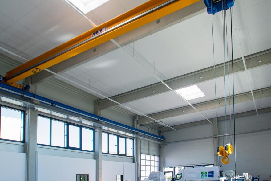 Ein Kran hängt von der Decke eines Gebäudes.