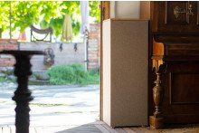 Eine Tür, die zu einer Terrasse führt, im Hintergrund ein Tisch und Stühle.