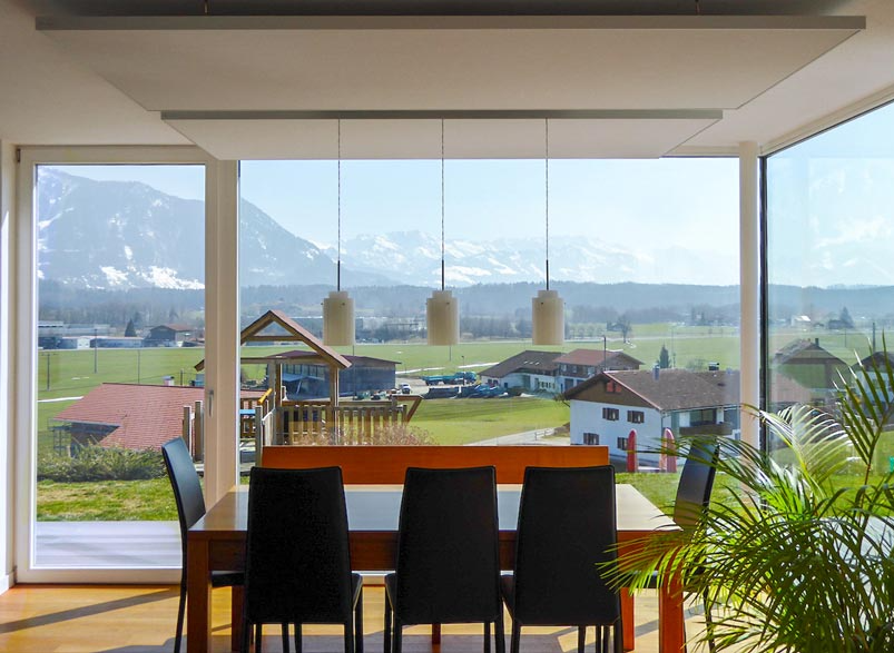 Ein Esszimmer mit Tisch und Stühlen und Blick auf die Berge
