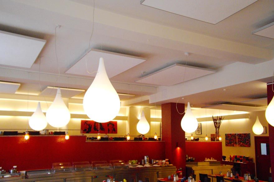 Ein Restaurant mit roten Wänden und weissen Lichtern, die von der Decke hängen