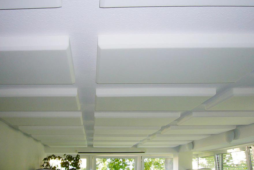 Ein Raum mit weißer Decke und vielen Fenstern.