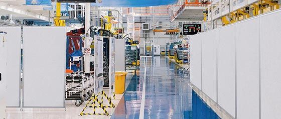 Ein unscharfes Bild einer Fabrik mit blauem Boden und weissen Wänden.