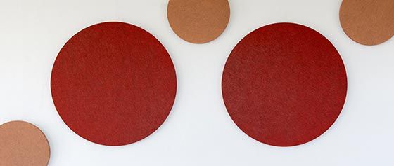 Auf einer weissen Wand befinden sich zwei rote und zwei braune Kreise.