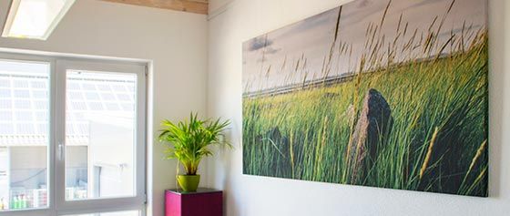 In einem Raum hängt an einer Wand ein grosses Gemälde eines Feldes.