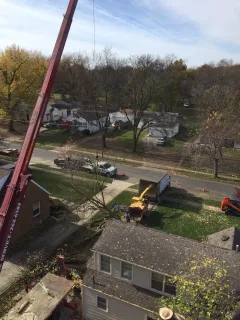 An aerial view of a crane working on a house.