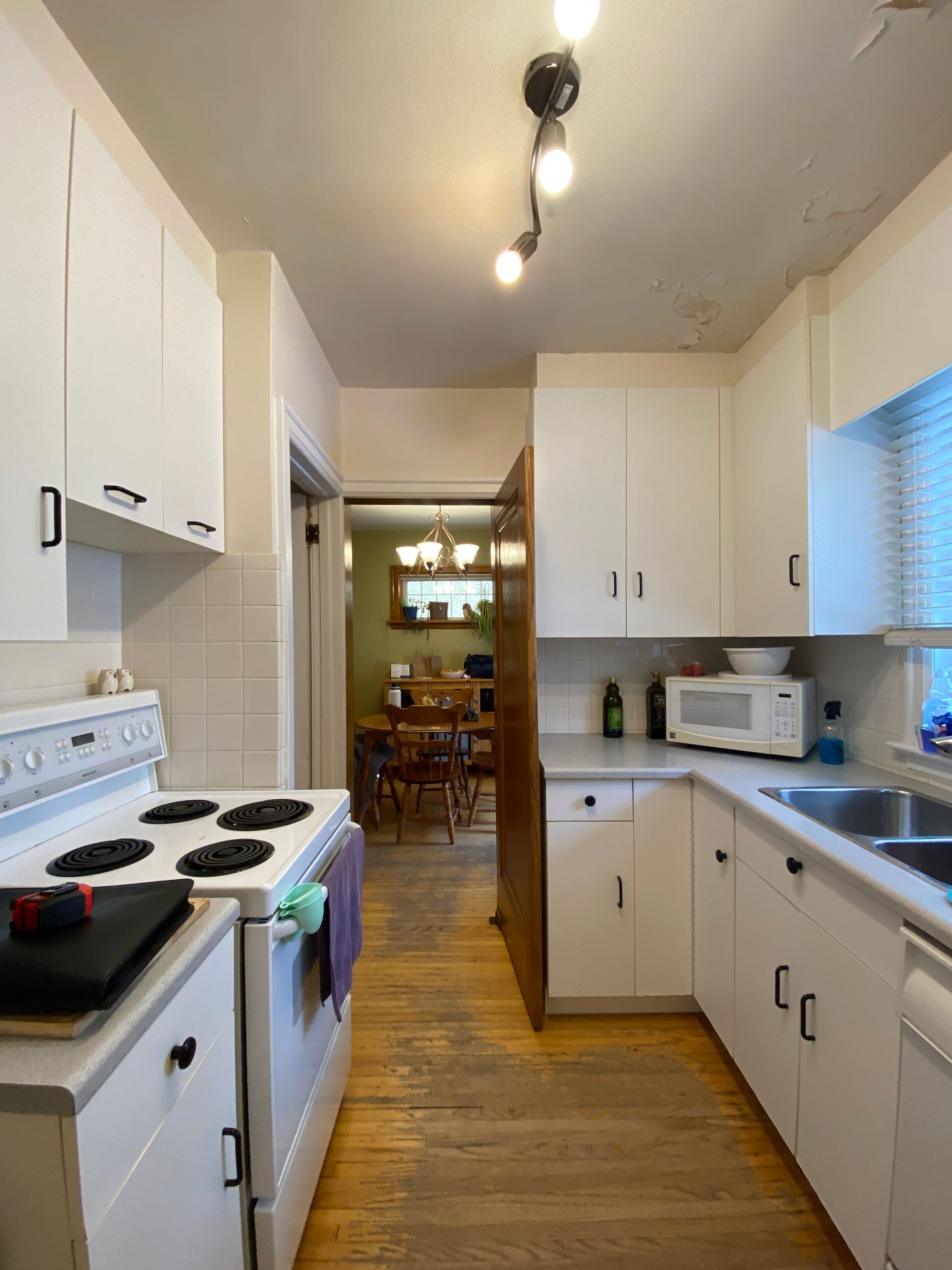 A kitchen with white cabinets and a stove top oven