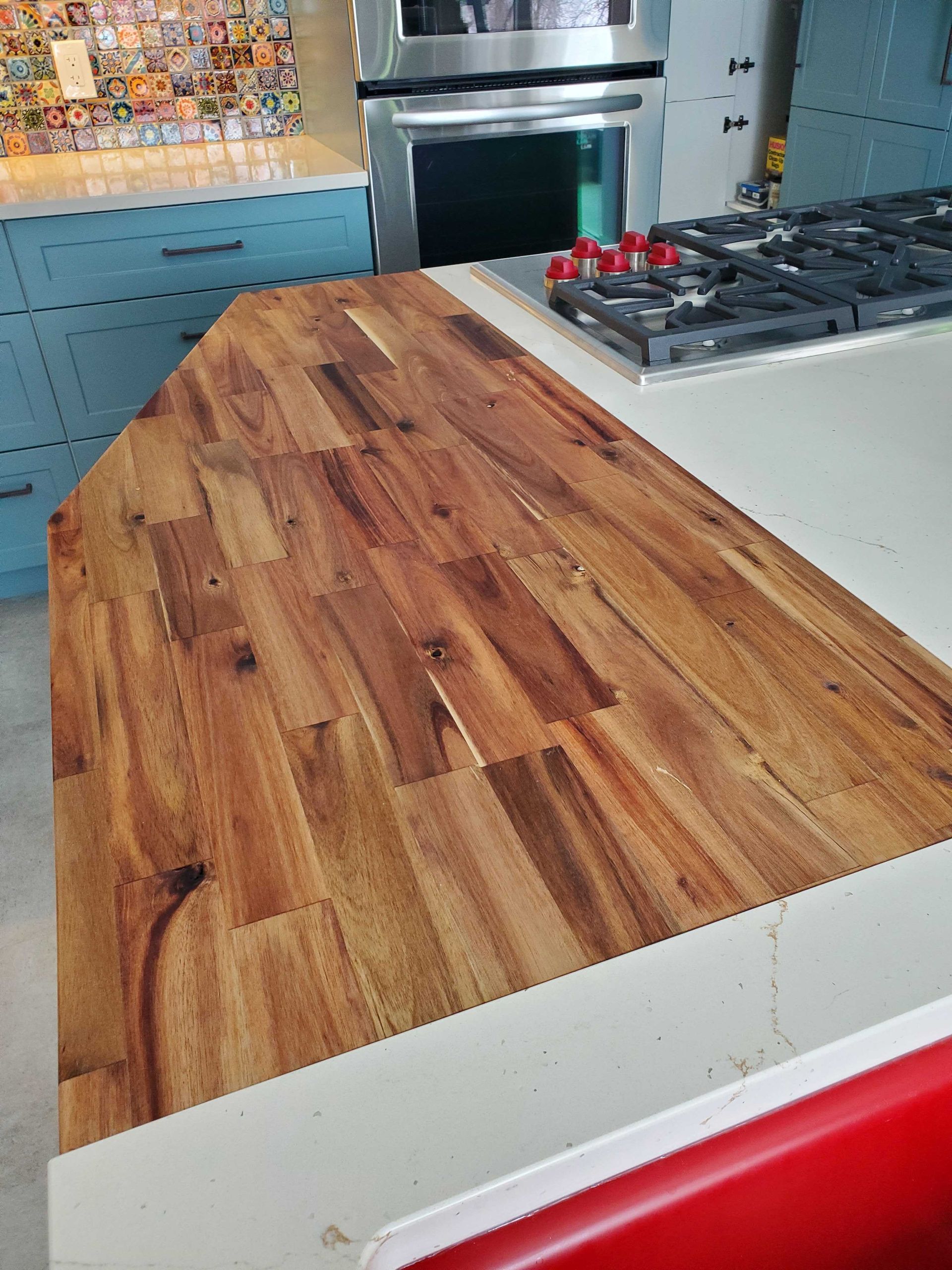 A kitchen with a wooden counter top and a stove top oven.