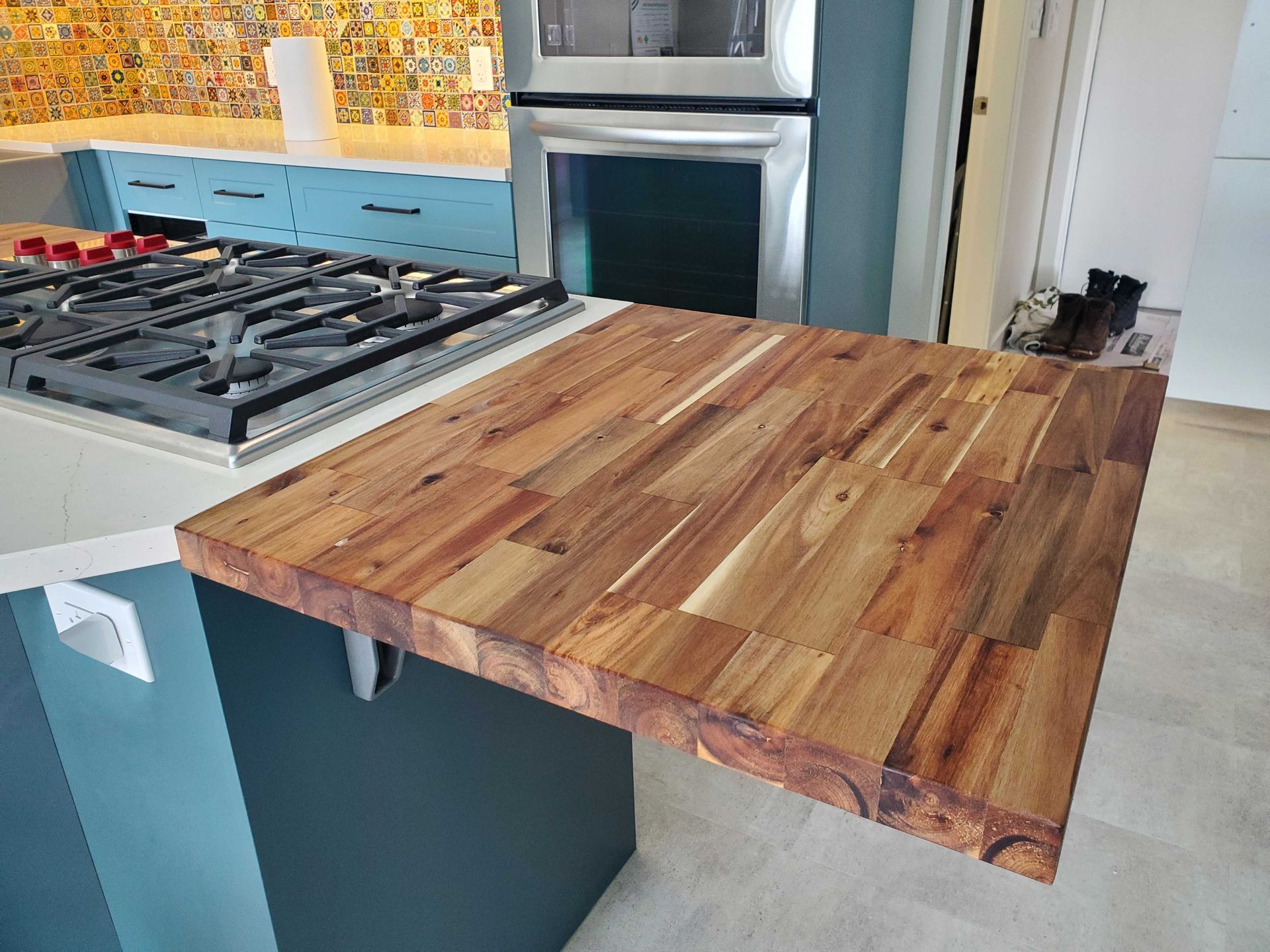 A kitchen with a wooden counter top and a stove top oven.