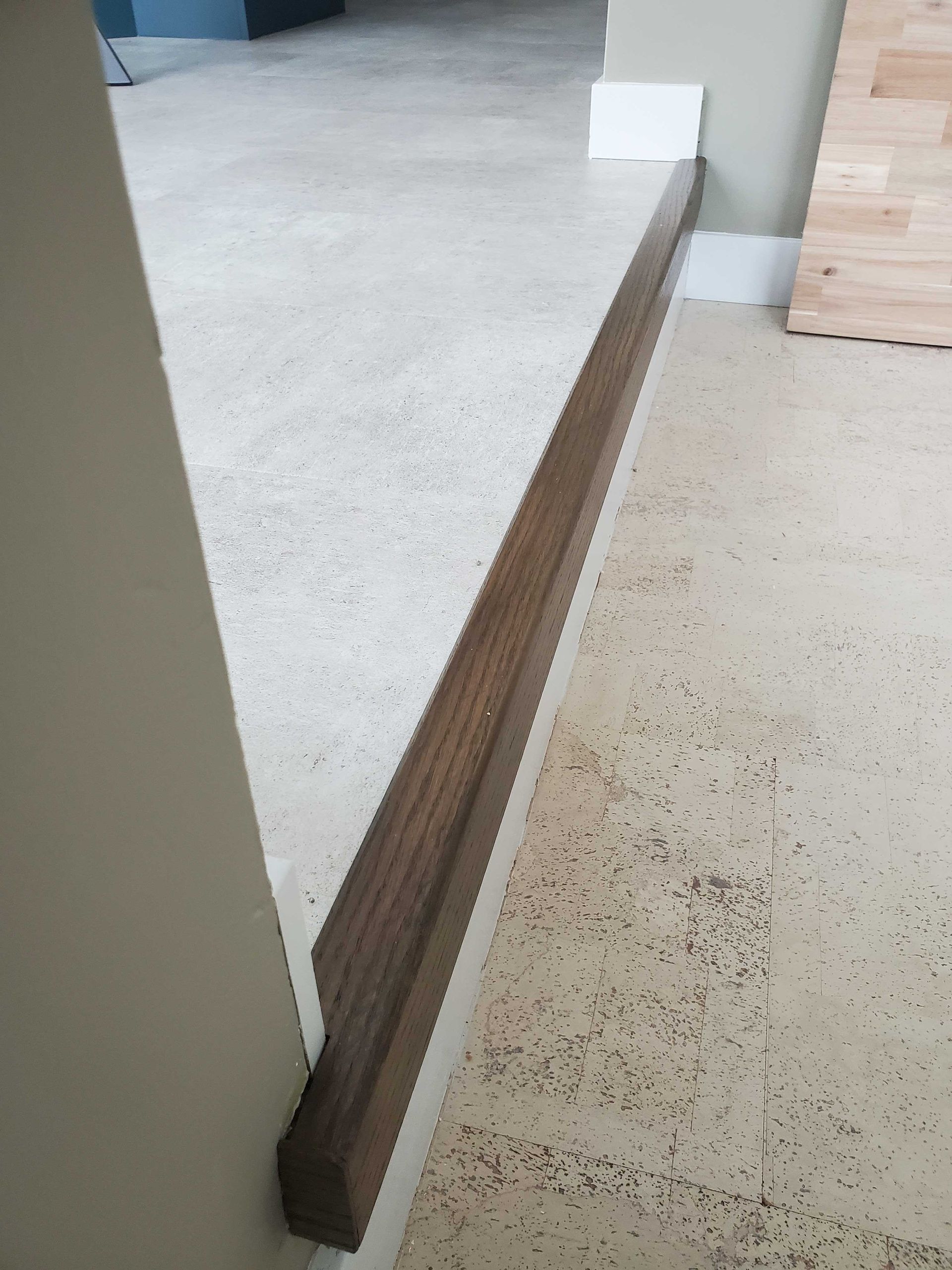 A wooden railing on a cork floor in a room