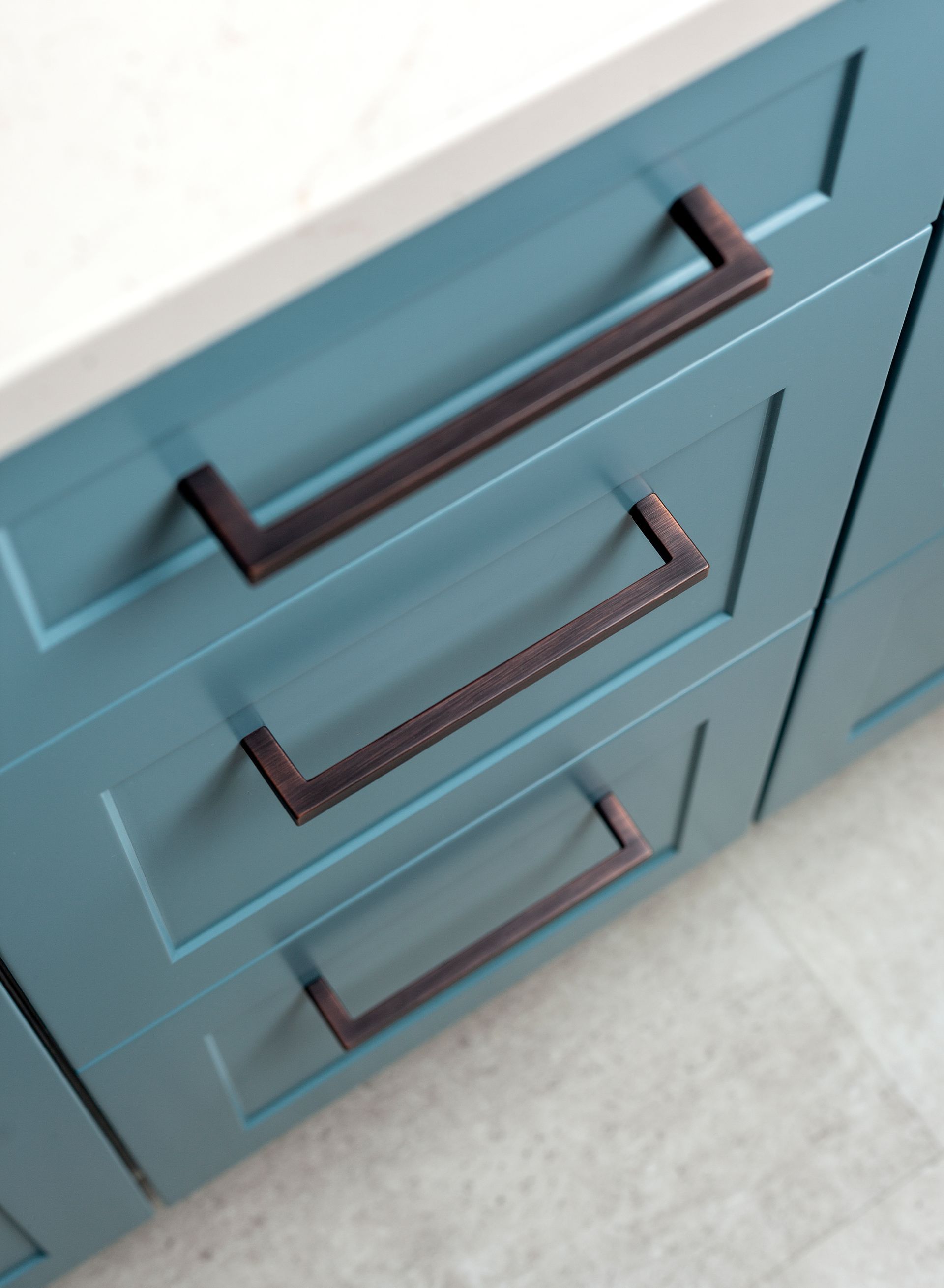 A close up of a blue cabinet with brown handles