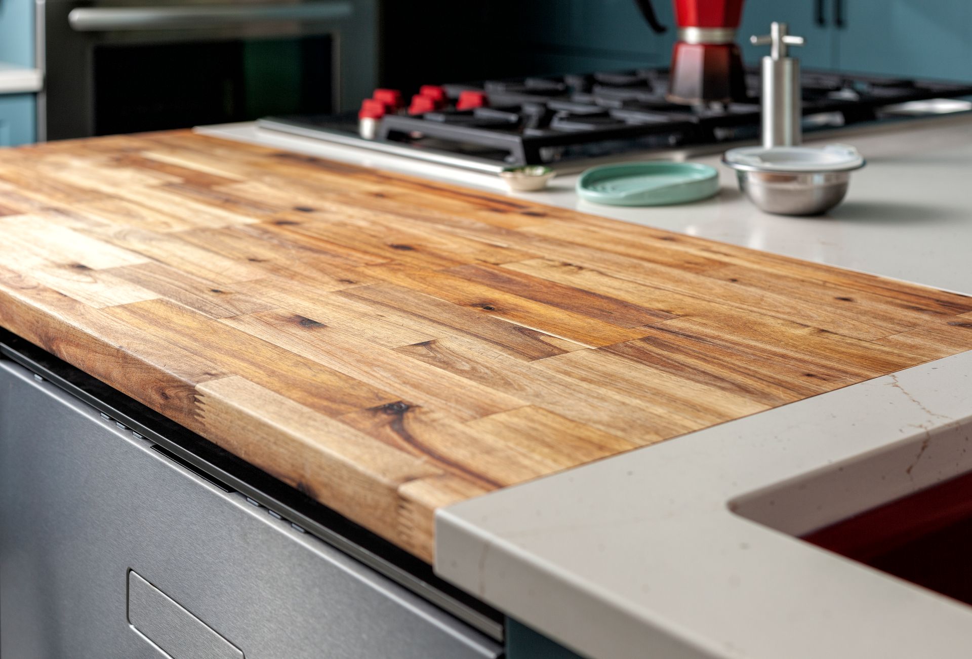 A kitchen counter with a wooden counter top and a stainless steel dishwasher.