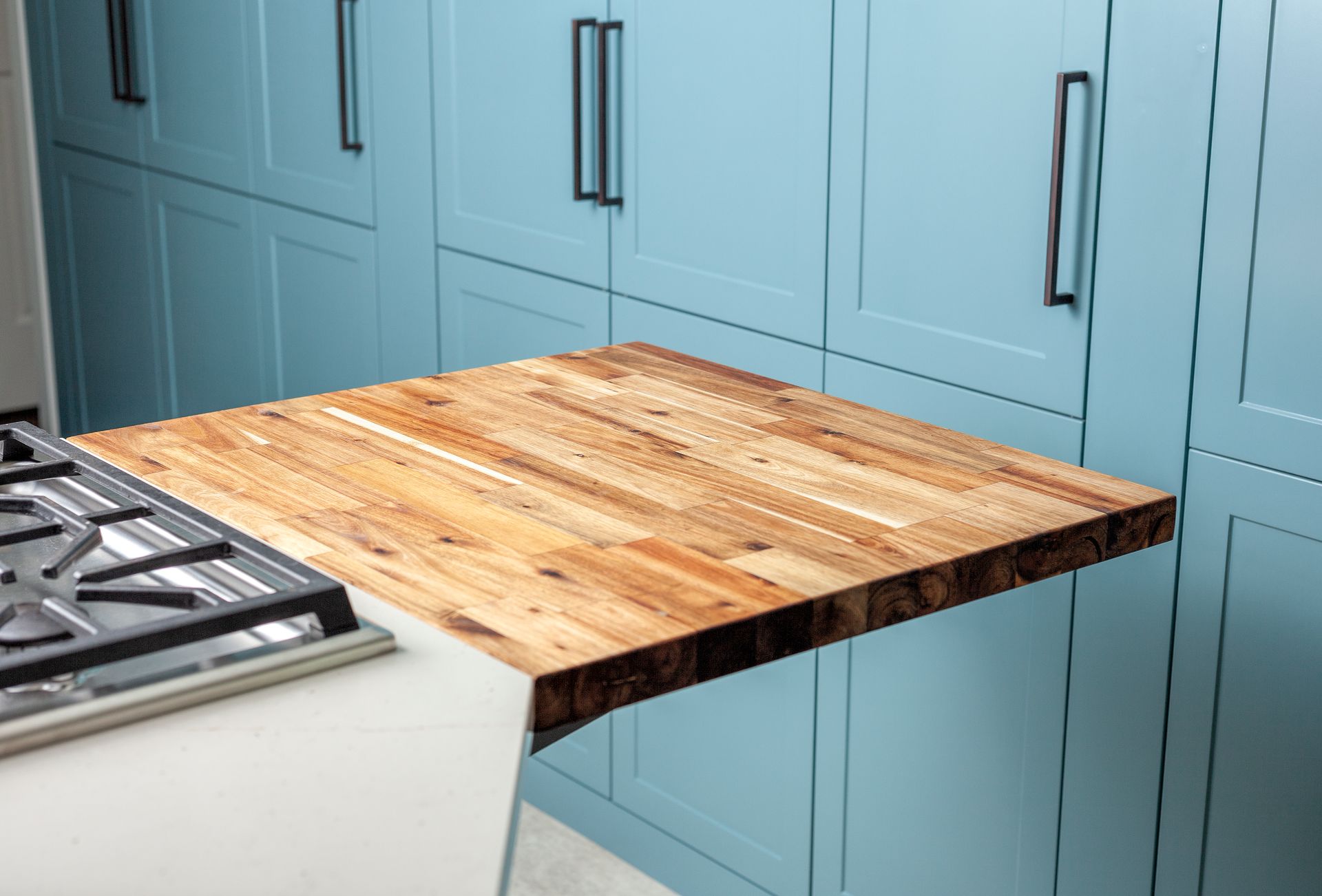 A wooden table is sitting on top of a stove in a kitchen.