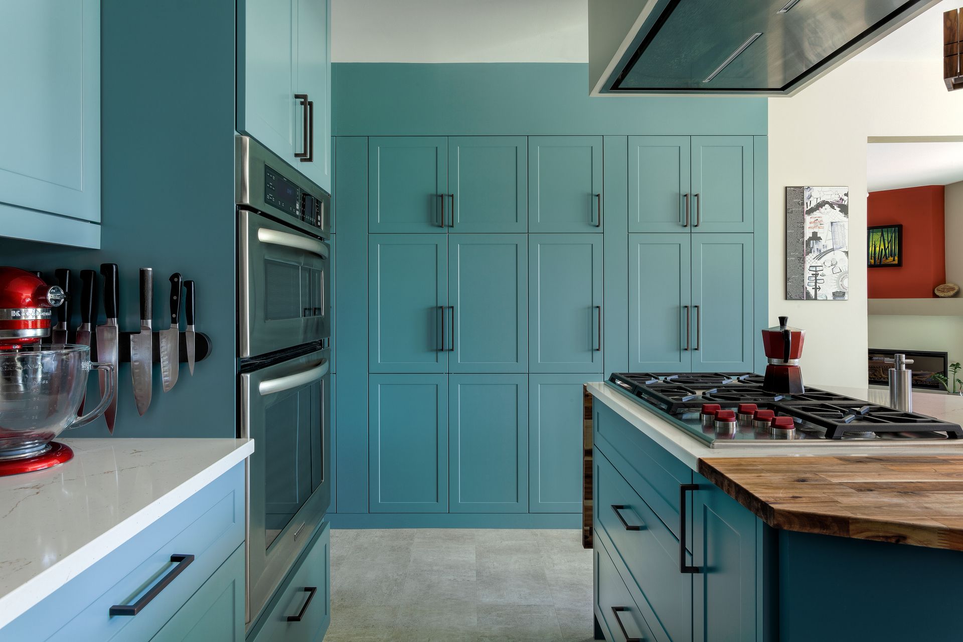 A kitchen with blue cabinets and a stove top oven.