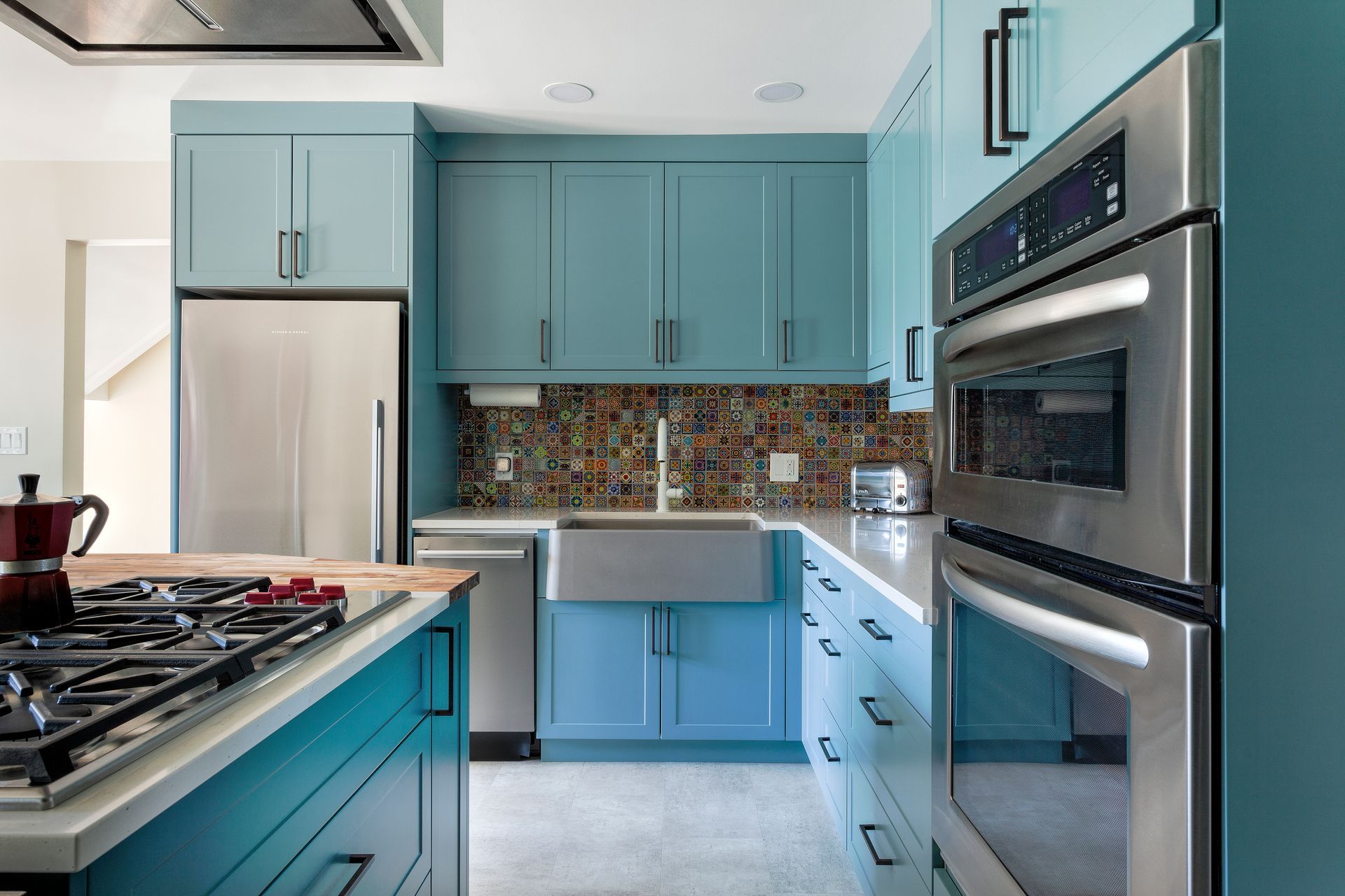 A kitchen with blue cabinets and stainless steel appliances.