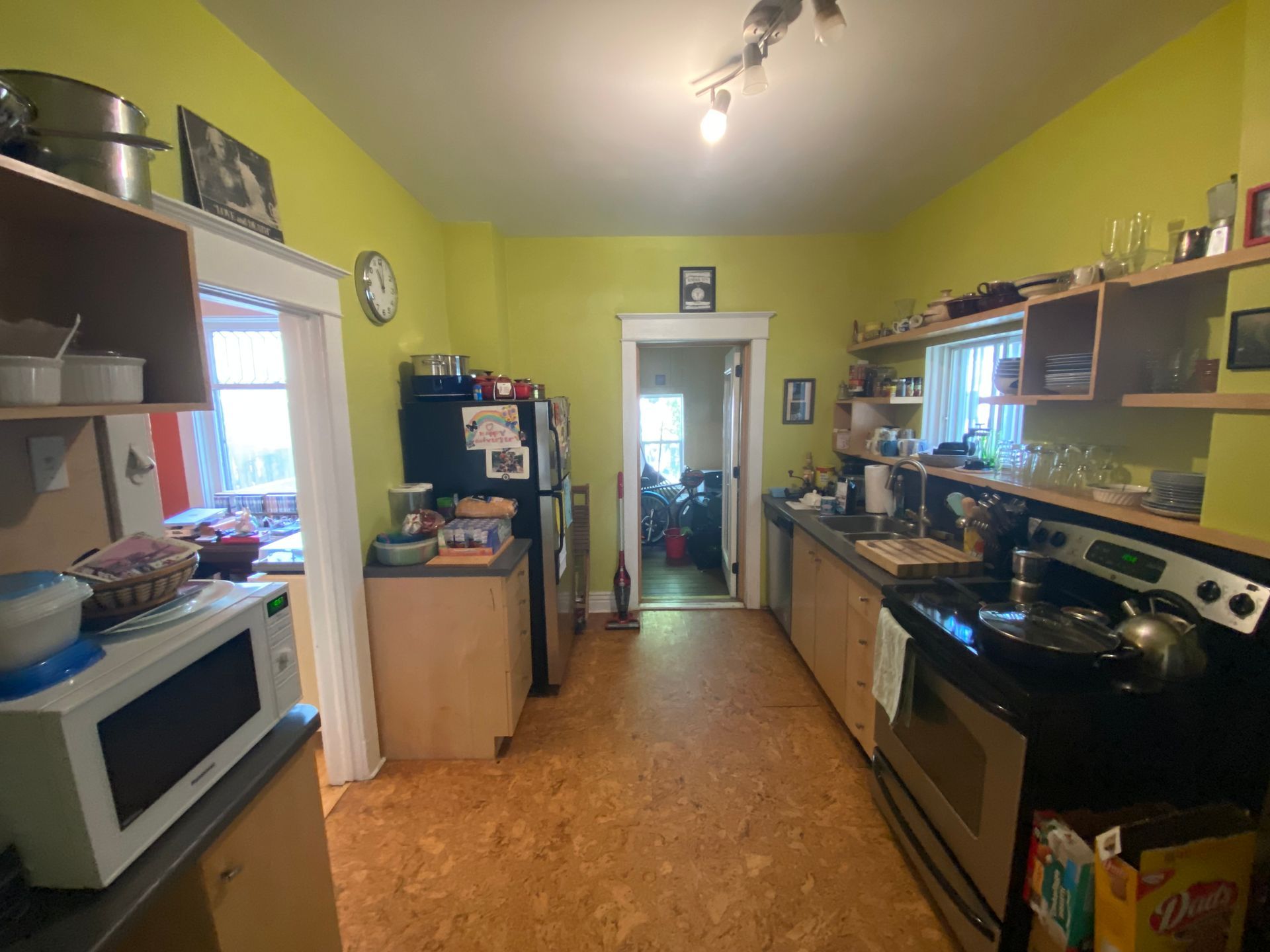 A kitchen with a stove , refrigerator and microwave