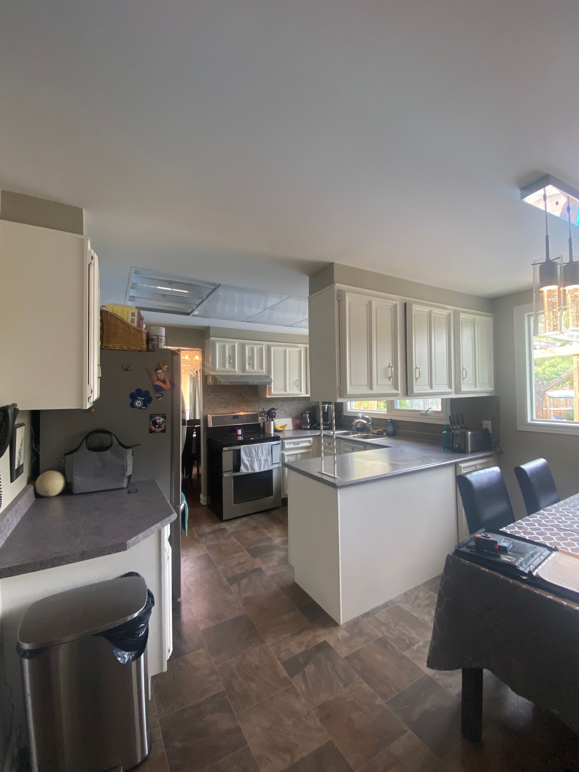 A kitchen with a table and chairs and a refrigerator.