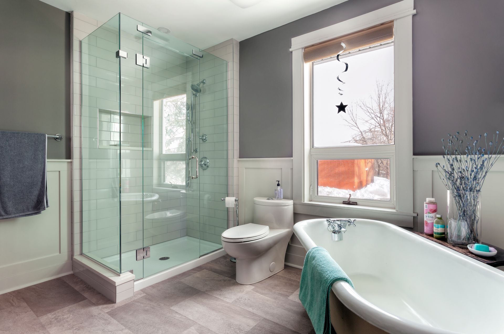 A bathroom with a tub, toilet, shower and window.