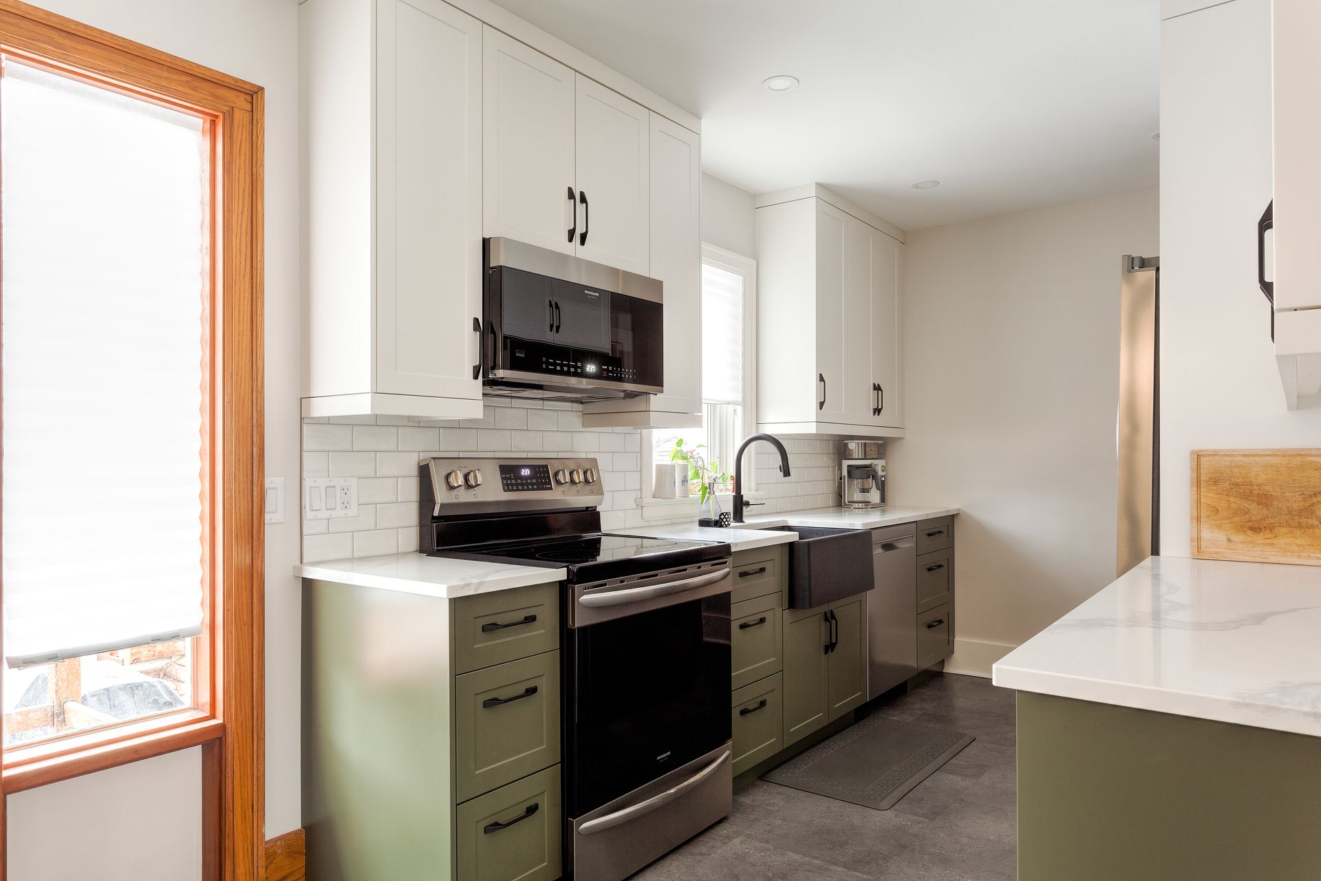 A kitchen with green cabinets and stainless steel appliances.