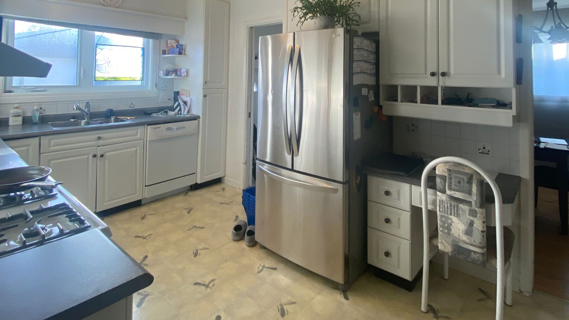 A kitchen with stainless steel appliances and white cabinets.