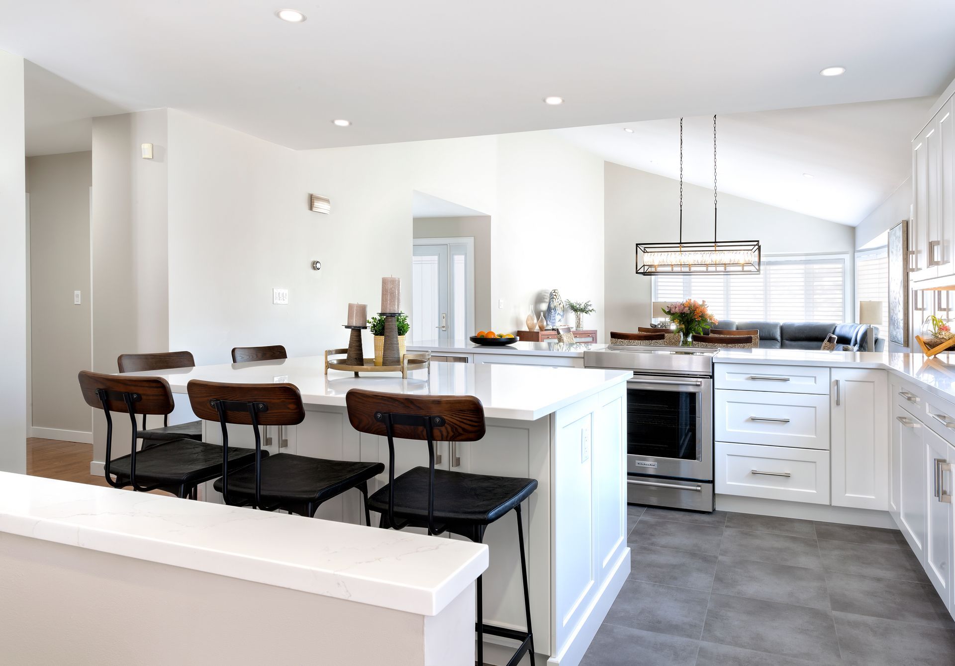 a kitchen with white cabinets , stainless steel appliances , and a large island .