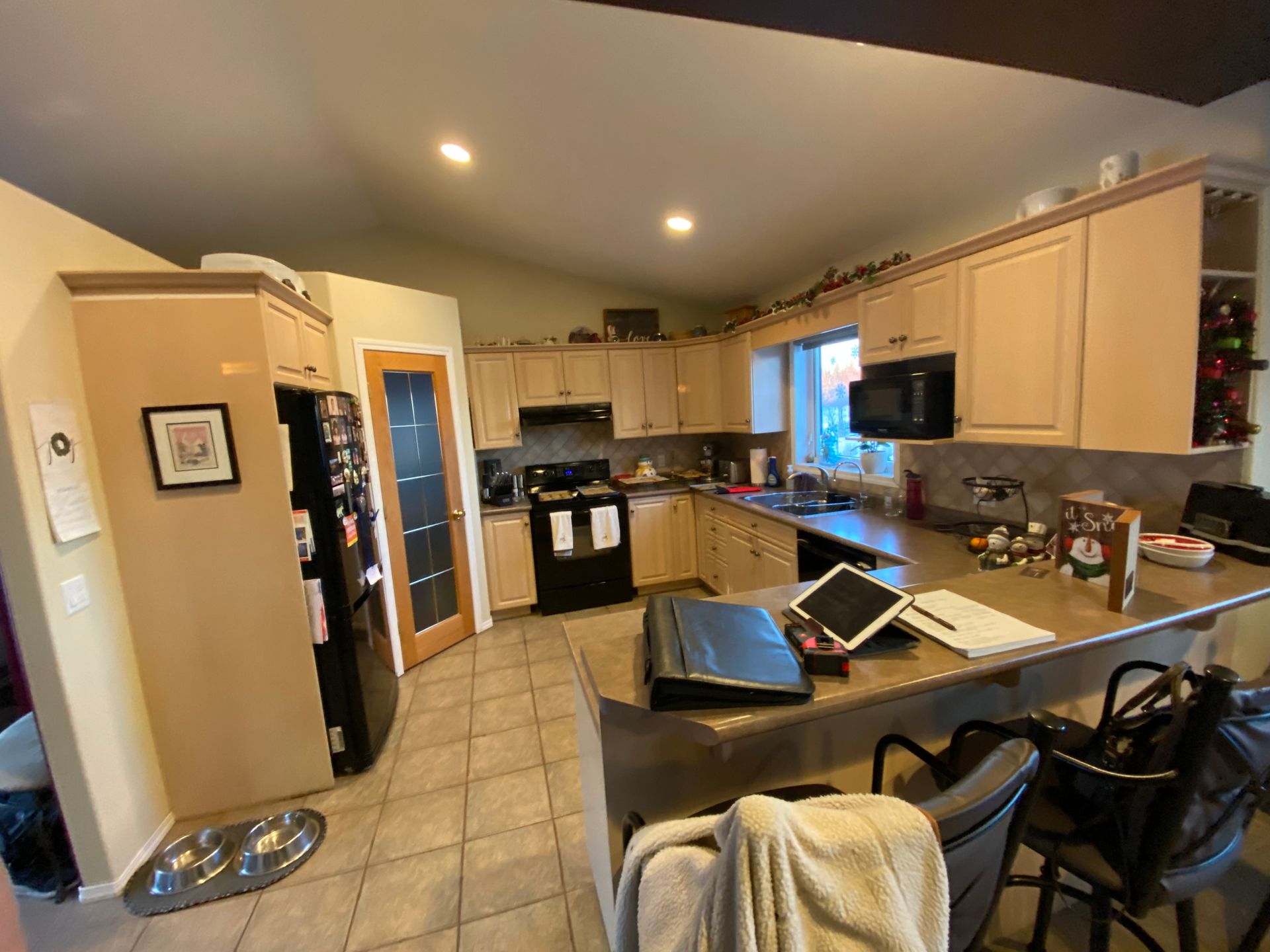 A kitchen with a stove , refrigerator , microwave and sink.